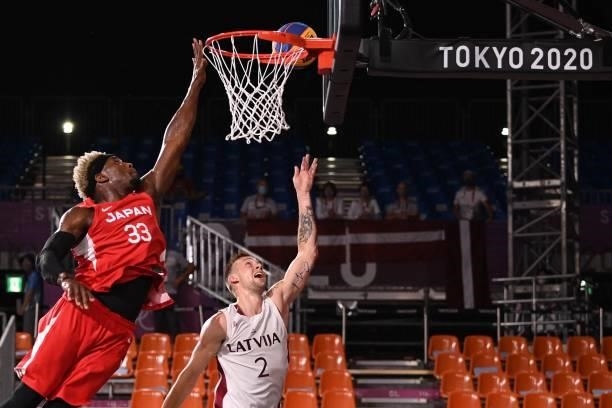 Japan's Ira Brown jumps and scores past Latvia's Karlis Lasmanis during the men's quarter final 3x3 basketball match between Latvia and Japan at the...