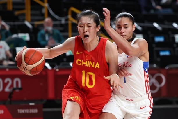 China's Pan Zhenqi dribbles the ball past Puerto Rico's Tayra Melendez in the women's preliminary round group C basketball match between China and...