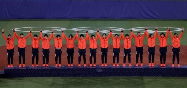 Gold medal winner, Japan's softball players pose on the podium during the medal ceremony for the softball competition in the Tokyo 2020 Olympic Games...