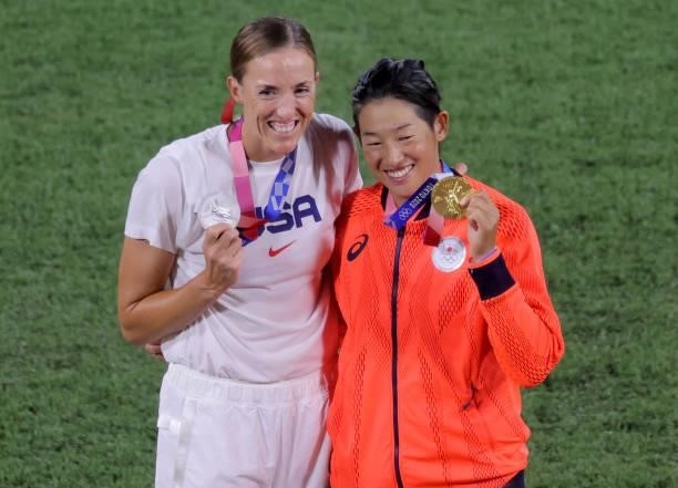 Japan's Yukiko Ueno and USA's Monica Abbott pose while holding their medals after the medal ceremony for the softball competition in the Tokyo 2020...