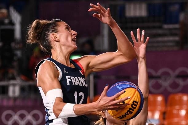 France's Laetitia Guapo jumps to score past Japan's Mio Shinozaki during the women's quarter final 3x3 basketball match between Japan and France at...