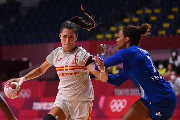 Spain's left back Lara Gonzalez Ortega is challenged by France's left wing Allison Pineau during the women's preliminary round group B handball match...
