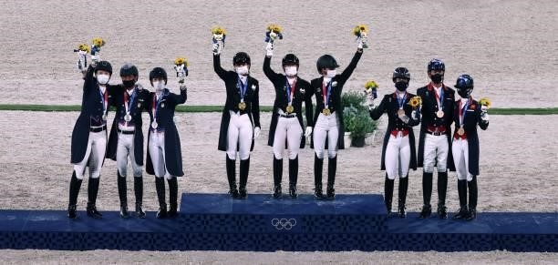Gold medallists of team Germany , silver medallists of the US team and Britain's Bronze medallists pose on the podium of the dressage grand prix...