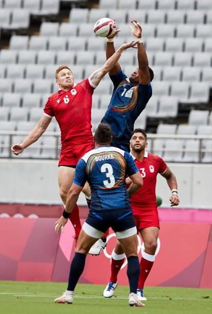 Connor Braid of Canada and Jose Seru of Japan battle for the ball during the Rugby Pool B match between Canada and Japan on day four of the Tokyo...