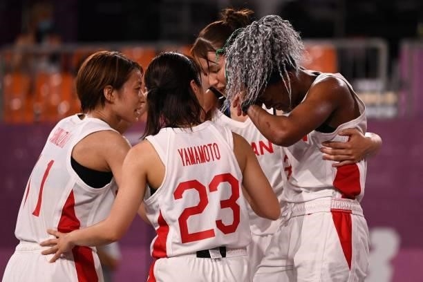 Japan's teammates react at the end of the women's quarter final 3x3 basketball match between Japan and France at the Aomi Urban Sports Park in Tokyo,...