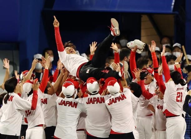 Japan's head coach Reika Utsugi is tossed in the air by her players after their victory in the Tokyo 2020 Olympic Games softball gold medal game...