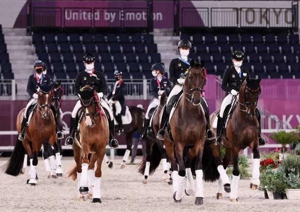 Medallists ride their horses together on the course after the medal ceremony of dressage grand prix special team competition during the Tokyo 2020...