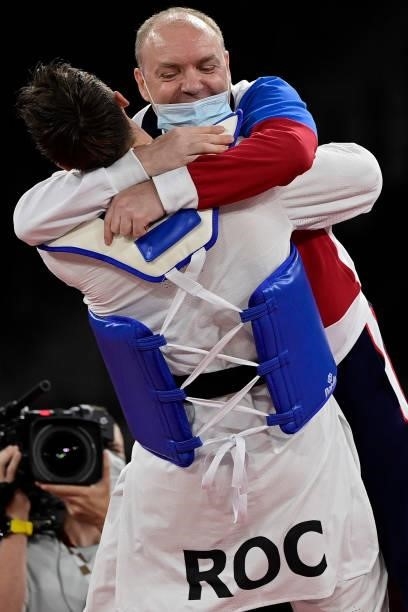 Russia's Vladislav Larin celebrates with his coach after winning the taekwondo men's +80kg gold medal bout during the Tokyo 2020 Olympic Games at the...