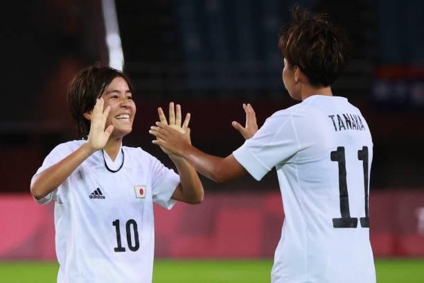 Japan's forward Mana Iwabuchi celebrates with Japan's forward Mina Tanaka after teir team won the Tokyo 2020 Olympic Games women's group E first...