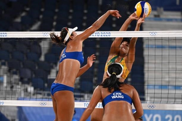 Brazil's Agatha Bednarczuk tries to block a shot by China's Xia Xinyi during their women's preliminary beach volleyball pool C match between Brazil...