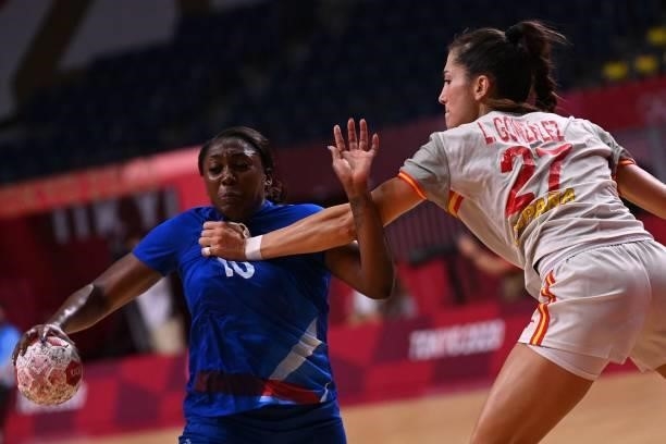 France's centre back Grace Zaadi Deuna is challenged by Spain's left back Lara Gonzalez Ortega during the women's preliminary round group B handball...