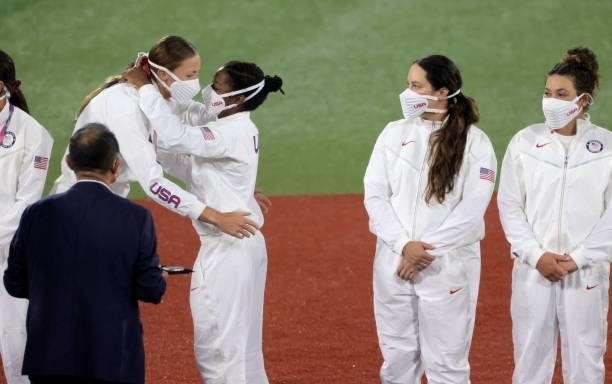 S pitcher Monica Abbott hugs outfielder Michelle Moultrie on the podium during the medal ceremony for the softball competition in the Tokyo 2020...