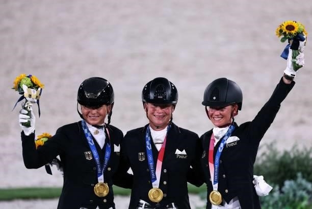 Gold medalist Germany's Dorothee Schneider, Isabell Werth and celebrate on the podium of the dressage grand prix special team competition during the...
