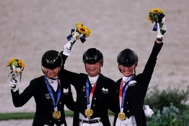 Gold medallists Germany's Dorothee Schneider, Isabell Werth and Jessica von Bredow-Werndl pose on the podium of the dressage grand prix special team...