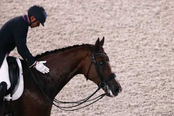 Steffen Peters of the US riding Suppenkasper caresses his horse after competing in the dressage grand prix special team competition during the Tokyo...