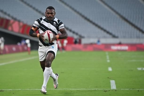 Fiji's Asaeli Tuivuaka runs to score a try in the men's final rugby sevens match between New Zealand and Fiji during the Tokyo 2020 Olympic Games at...