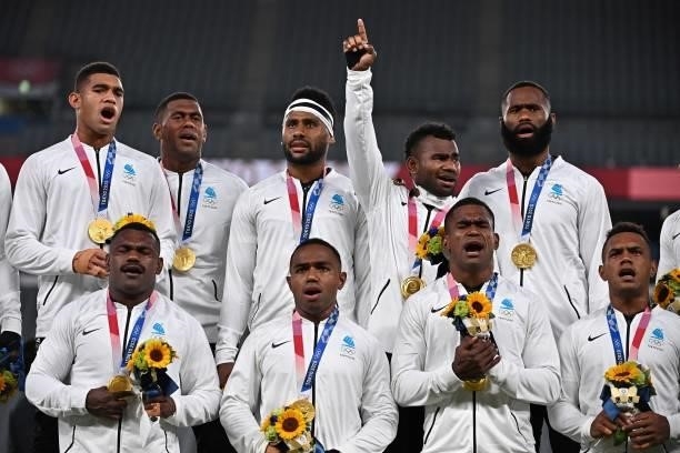 Fiji's players sing on the podium with their gold medals after the victory ceremony following the men's final rugby sevens match during the Tokyo...