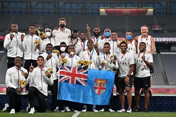 Fiji's players celebrate with their gold medals while standing on the podium after the victory ceremony following the men's final rugby sevens match...