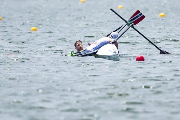 Kristoffer Brun of Norway and Are Weierholt Strandli of Norwegen lie in the water during the men's semi-final in the lightweight double sculls during...