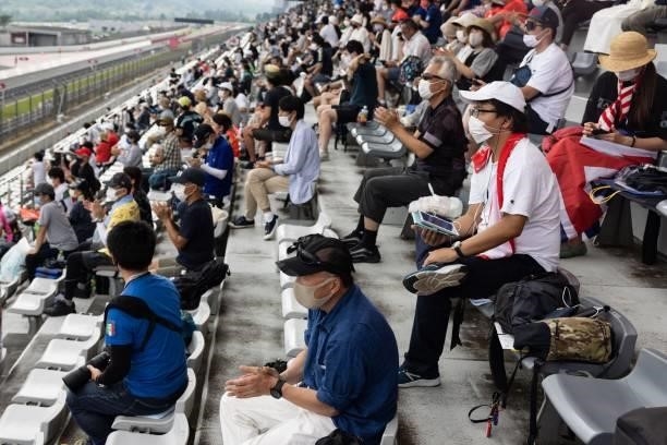 Spectators watch the men's cycling road individual time trial during the Tokyo 2020 Olympic Games at the Fuji International Speedway in Oyama,...