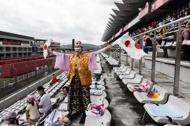 Olympic super-fan Kyoko Ishikawa waves the Japan national flags during the women's cycling road individual time trial during the Tokyo 2020 Olympic...