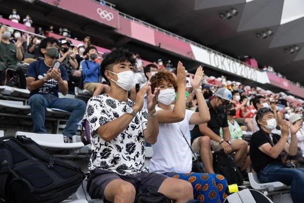 Fans cheer from the spectator stands during the victory ceremony for the men's cycling road individual time trial of the Fuji International Speedway...