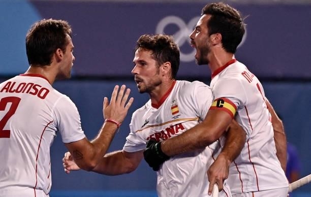 Spain's Pau Quemada celebrates with teammates Alejandro Alonso and Miguel Delas De Andres after scoring against Japan during their men's pool A match...