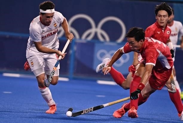 Spain's Enrique Gonzalez and Japan's Yoshiki Kirishita vie for the ball during their men's pool A match of the Tokyo 2020 Olympic Games field hockey...