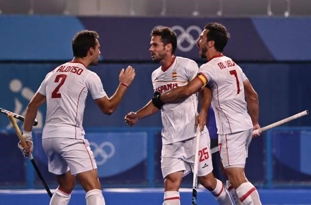 Spain's Pau Quemada celebrates with teammates Alejandro Alonso and Miguel Delas De Andres after scoring against Japan during their men's pool A match...