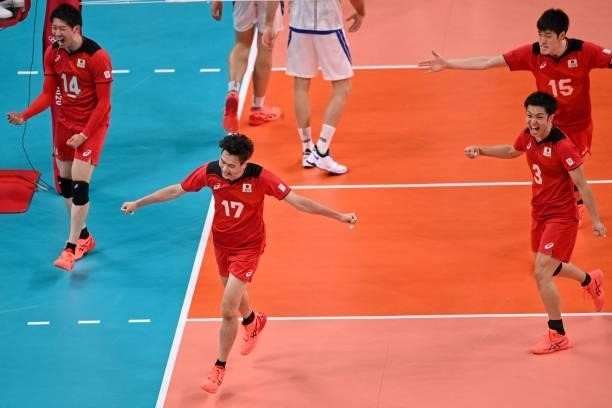 Japan's players react after a point in the men's preliminary round pool A volleyball match between Japan and Italy during the Tokyo 2020 Olympic...