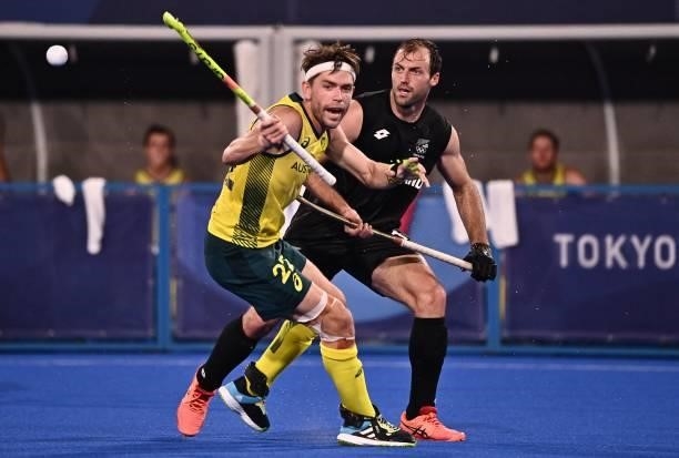 Australia's Flynn Andrew Ogilvie and New Zealand's Nic Woods vie for the ball during their men's pool A match of the Tokyo 2020 Olympic Games field...