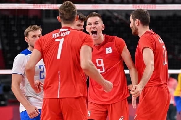 Russia's Ivan Iakovlev and Dmitry Volkov celebrate their victory in the men's preliminary round pool B volleyball match between Brazil and Russia...