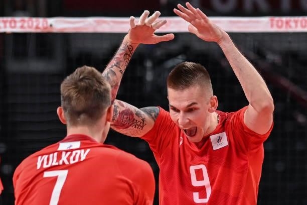 Russia's Ivan Iakovlev and Dmitry Volkov celebrate their victory in the men's preliminary round pool B volleyball match between Brazil and Russia...