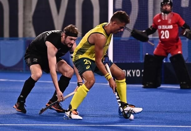 Australia's Tim Brand is challenged by New Zealand's Blair Tarrant during their men's pool A match of the Tokyo 2020 Olympic Games field hockey...