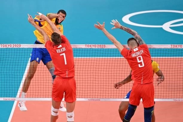 Russia's Dmitry Volkov attempts to block a shot by Brazil's Wallace de Souza in the men's preliminary round pool B volleyball match between Brazil...