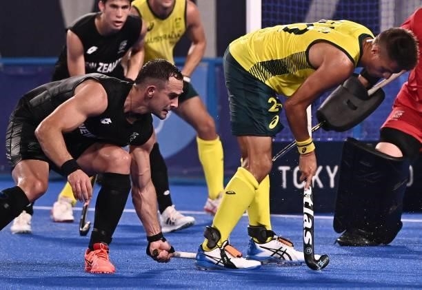 Australia's Tim Brand is challenged by New Zealand's Dane Lett during their men's pool A match of the Tokyo 2020 Olympic Games field hockey...