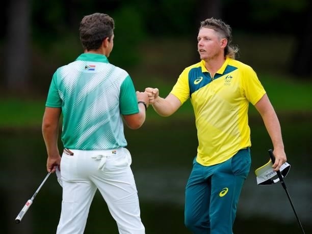 South Africa's Garrick Higgo touches fists with Australia's Cameron Smith on the 18th green in round 1 of the mens golf individual stroke play during...