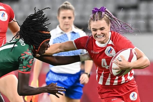 Russia's Alena Tiron fends off a tackle by Kenya's Camilla Atieno during the women's pool A rugby sevens match between the Russia and Kenya during...