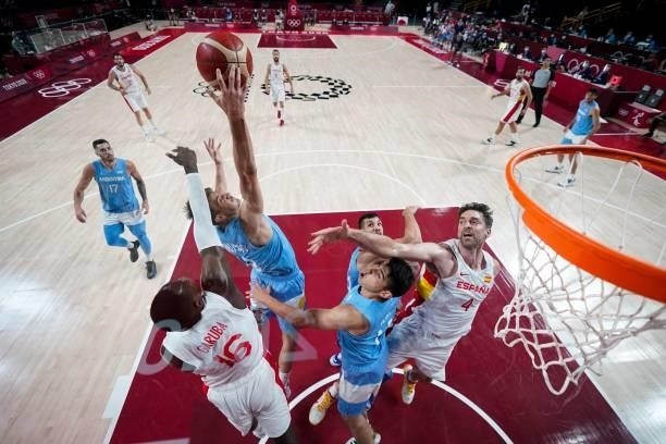 Spain's Usman Garuba and Argentina's Nicolas Brussino jump for a rebound during the men's preliminary round group C basketball match between Spain...
