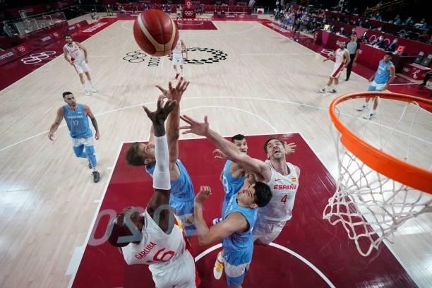 Spain's Usman Garuba jumps for a rebound with Argentina's Gabriel Deck in the men's preliminary round group C basketball match between Spain and...