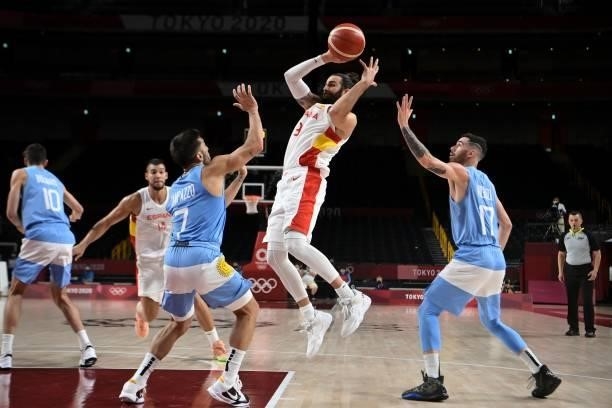 Spain's Ricky Rubio jumps for the ball between Argentina's Facundo Campazzo and Luca Vildoza in the men's preliminary round group C basketball match...