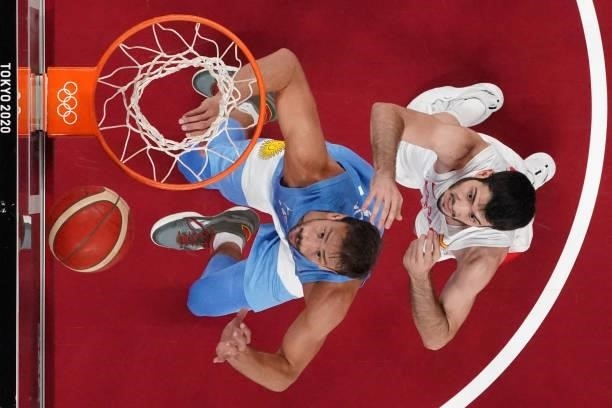 Argentina's Marcos Delia and Spain's Alex Abrines jump for the ball in the men's preliminary round group C basketball match between Spain and...