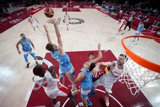 Spain's Usman Garuba and Argentina's Nicolas Brussino jump for a rebound during the men's preliminary round group C basketball match between Spain...