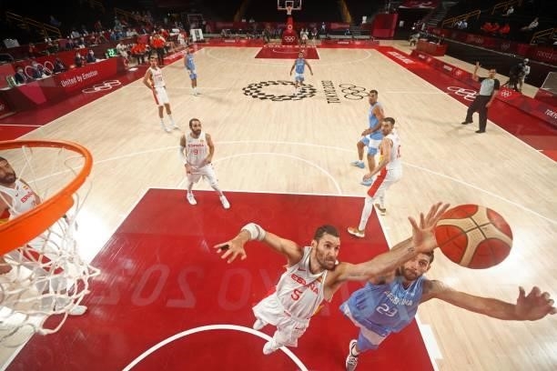 Argentina's Patricio Garino and Spain's Rudy Fernandez jumps for the ball in the men's preliminary round group C basketball match between Spain and...