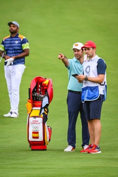 Jorge Campillo of Team Spain points with his caddie and his bag on the 18th hole fairway during the first round of Mens Individual Stroke Play Golf...