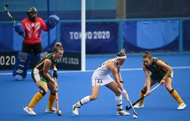 Germany's Cecile Pieper is challenged by South Africa's Nicole Walraven and Kristen Paton during their women's pool A match of the Tokyo 2020 Olympic...