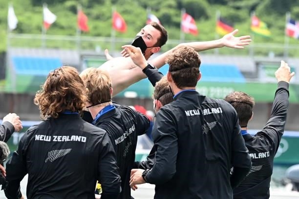 Gold medal winners New Zealand rowers throw their coxswain Sam Bosworth in the water following the men's eight final during the Tokyo 2020 Olympic...