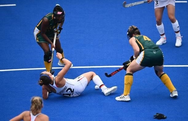 Germany's Charlotte Stapenhorst falls as she is marked by South Africa's Edith Molikoe and Nicole Walraven during their women's pool A match of the...