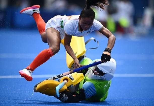 India's Lalremsiami falls over Ireland's goalkeeper Ayeisha McFerran during their women's pool A match of the Tokyo 2020 Olympic Games field hockey...