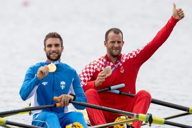 Gold medalist Stefanos Ntouskos of Team Greece and bronze medalist Damir Martin of Team Croatia pose with their medals on their boats after the Men's...